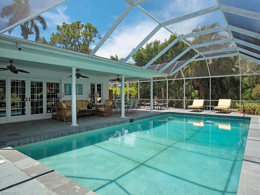 745 Pectin Road Naples, FL 34102 - Photo 2 of 18 a view of a swimming pool with a patio