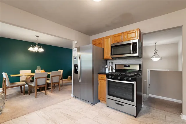 a living room with furniture a flat screen tv and kitchen view
