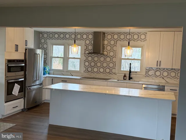 a kitchen with stainless steel appliances a sink and a refrigerator