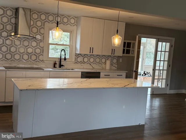 a view of a kitchen with a sink a chandelier and wooden floor