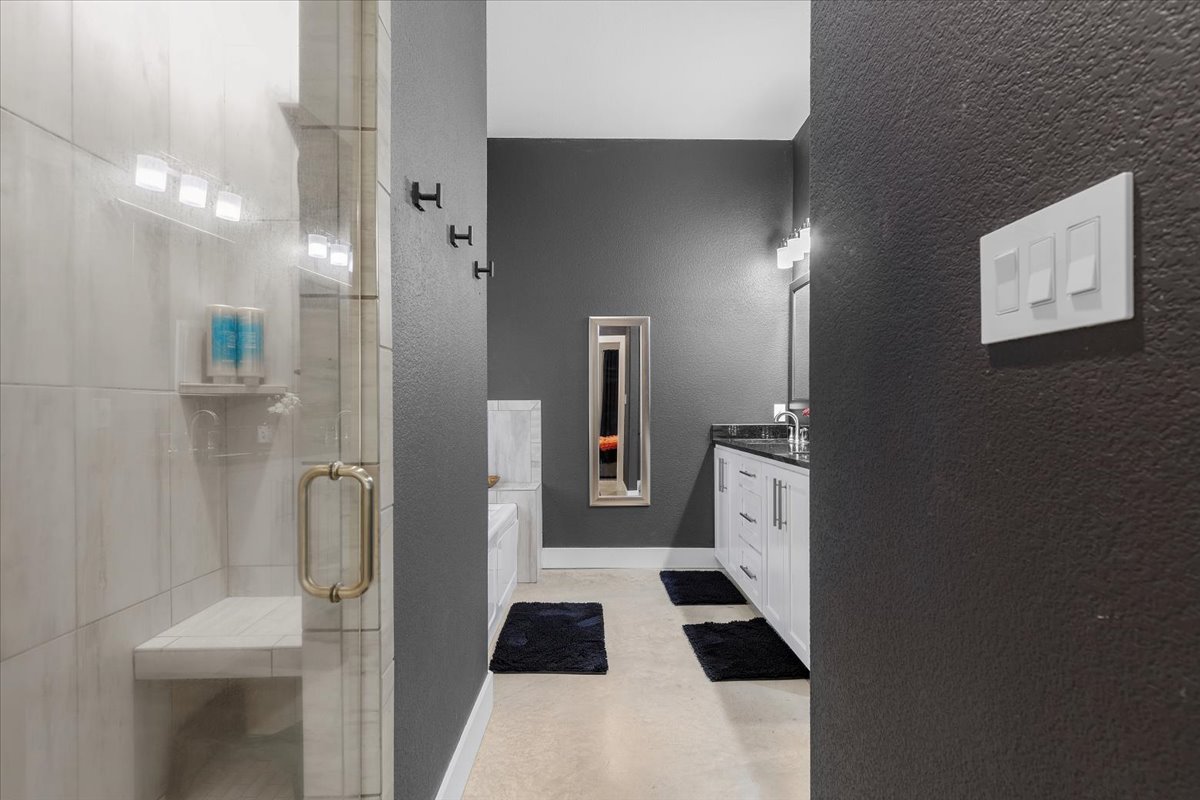 145 Cardinal Loop Paige, TX 78659 - Photo 26 of 40 A sleek modern bathroom featuring a spacious walk-in shower and elegant vanity with ample storage.