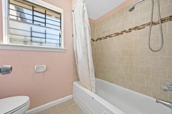 a bathroom with a granite countertop bathtub a window and a shower