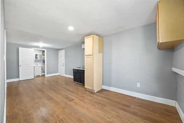 a view of a kitchen with refrigerator and wooden floor