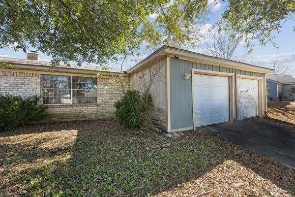 a backyard of a house with large trees and outdoor seating