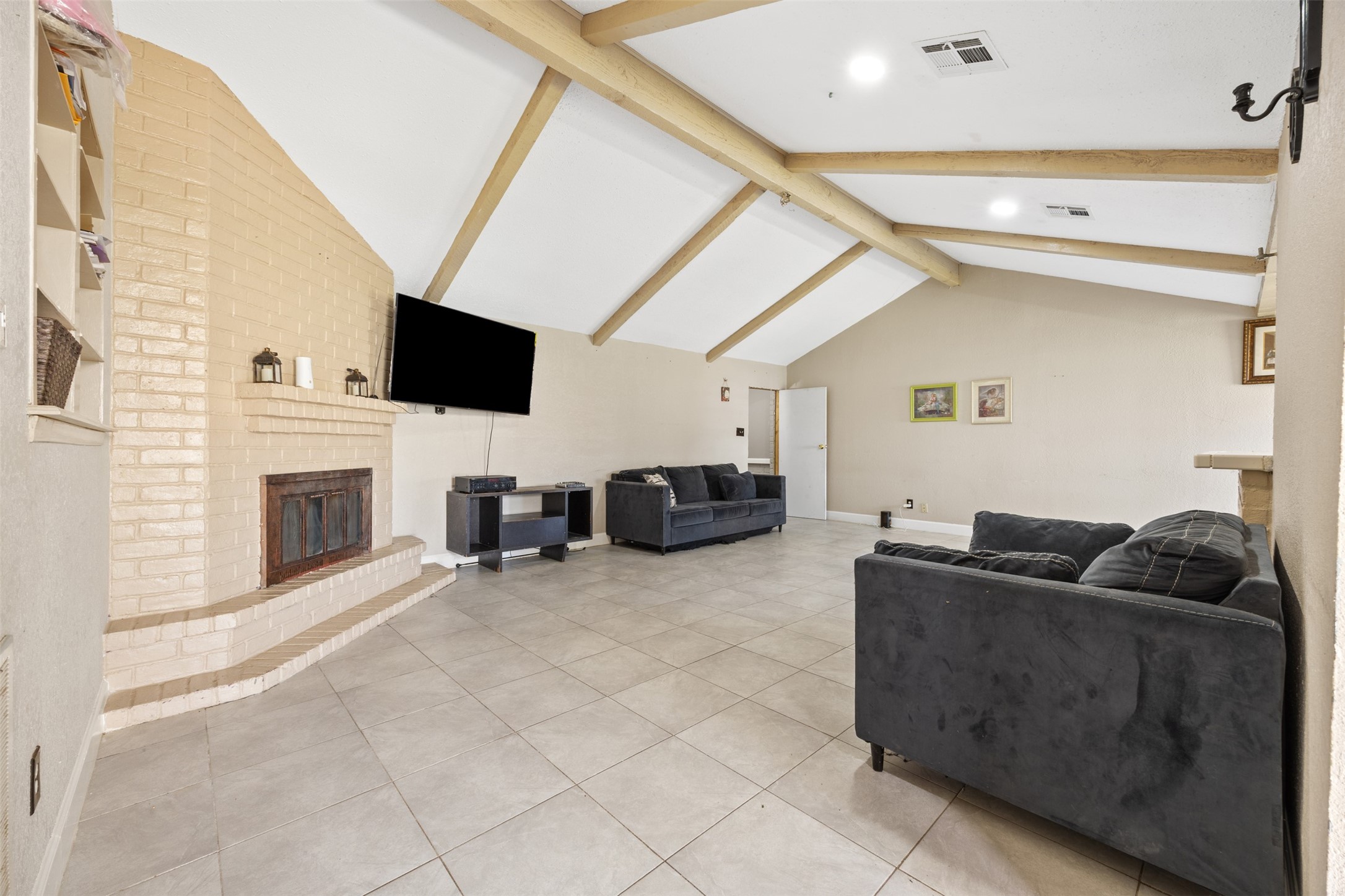 6715 Rowell Court Houston, TX 77489 - Photo 4 of 24 a living room with furniture a flat screen tv and a fireplace