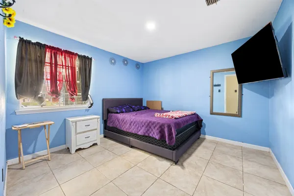 a spacious bedroom with a bed and window