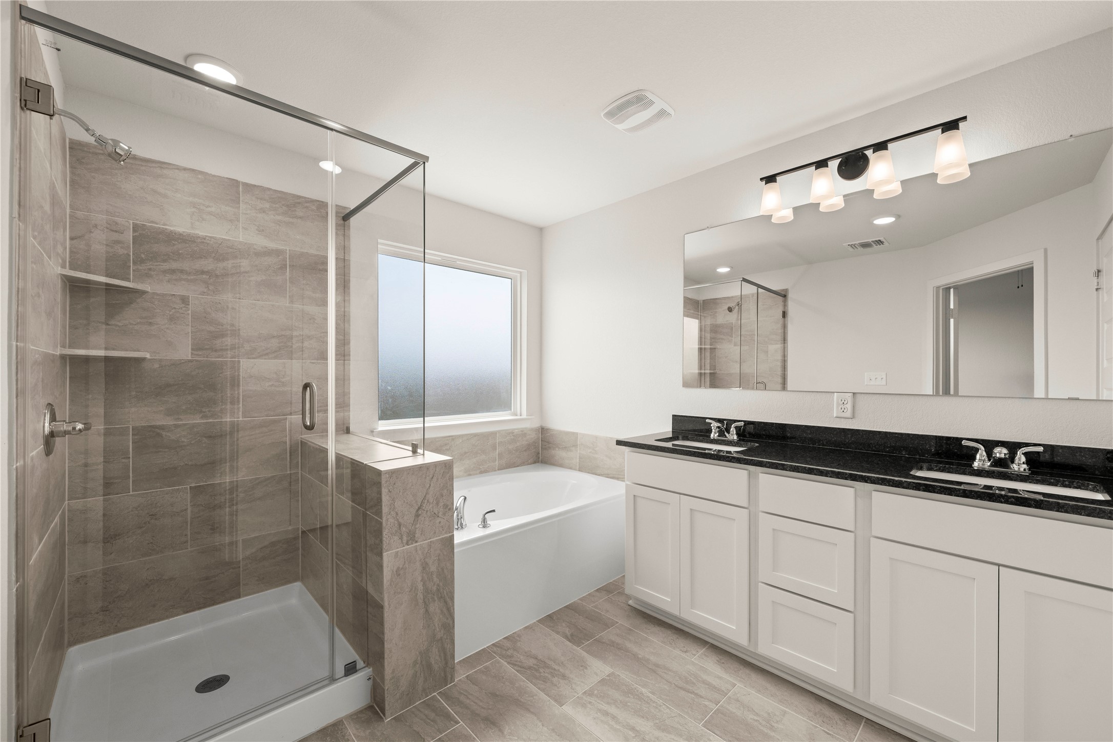247 Gus Loop Georgetown, TX 78626 - Photo 11 of 17 A spacious bathroom features a glass-enclosed walk-in shower and a soaking tub.
