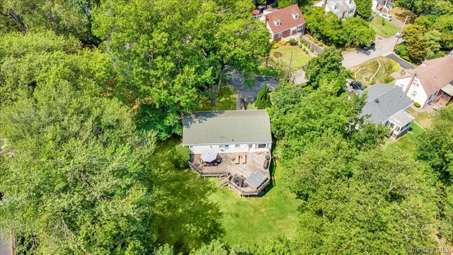 an aerial view of residential house with outdoor space and trees all around