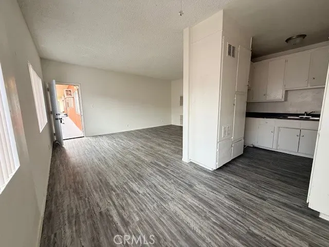 a view of a kitchen with wooden floor and electronic appliances