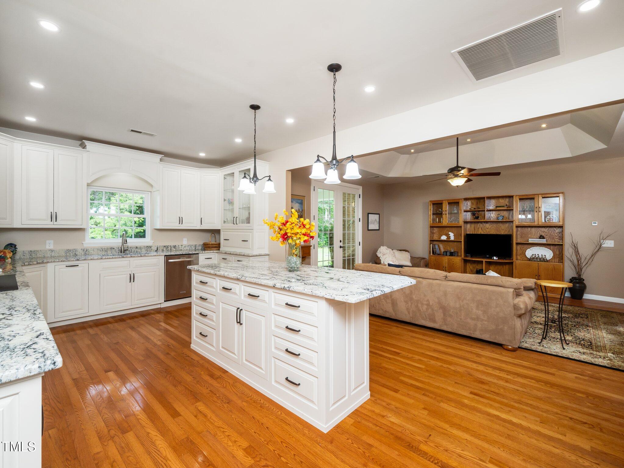 8917 Thompson Mill Road Wake Forest, NC 27587 - Photo 12 of 42 a kitchen with stainless steel appliances granite countertop a sink a stove and a wooden floors