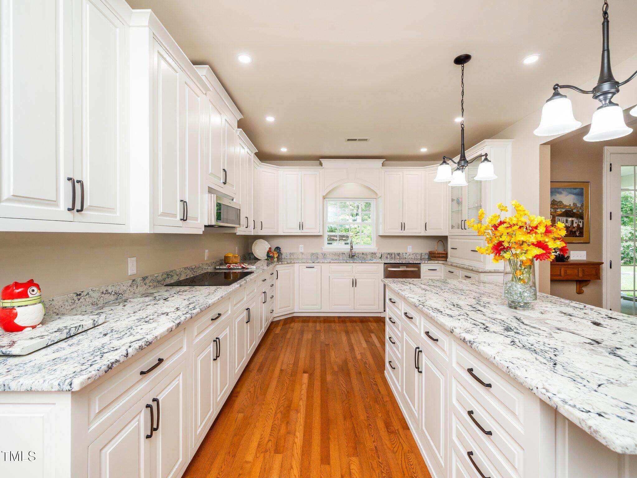 8917 Thompson Mill Road Wake Forest, NC 27587 - Photo 13 of 42 a large kitchen with granite countertop lots of counter space and wooden floor