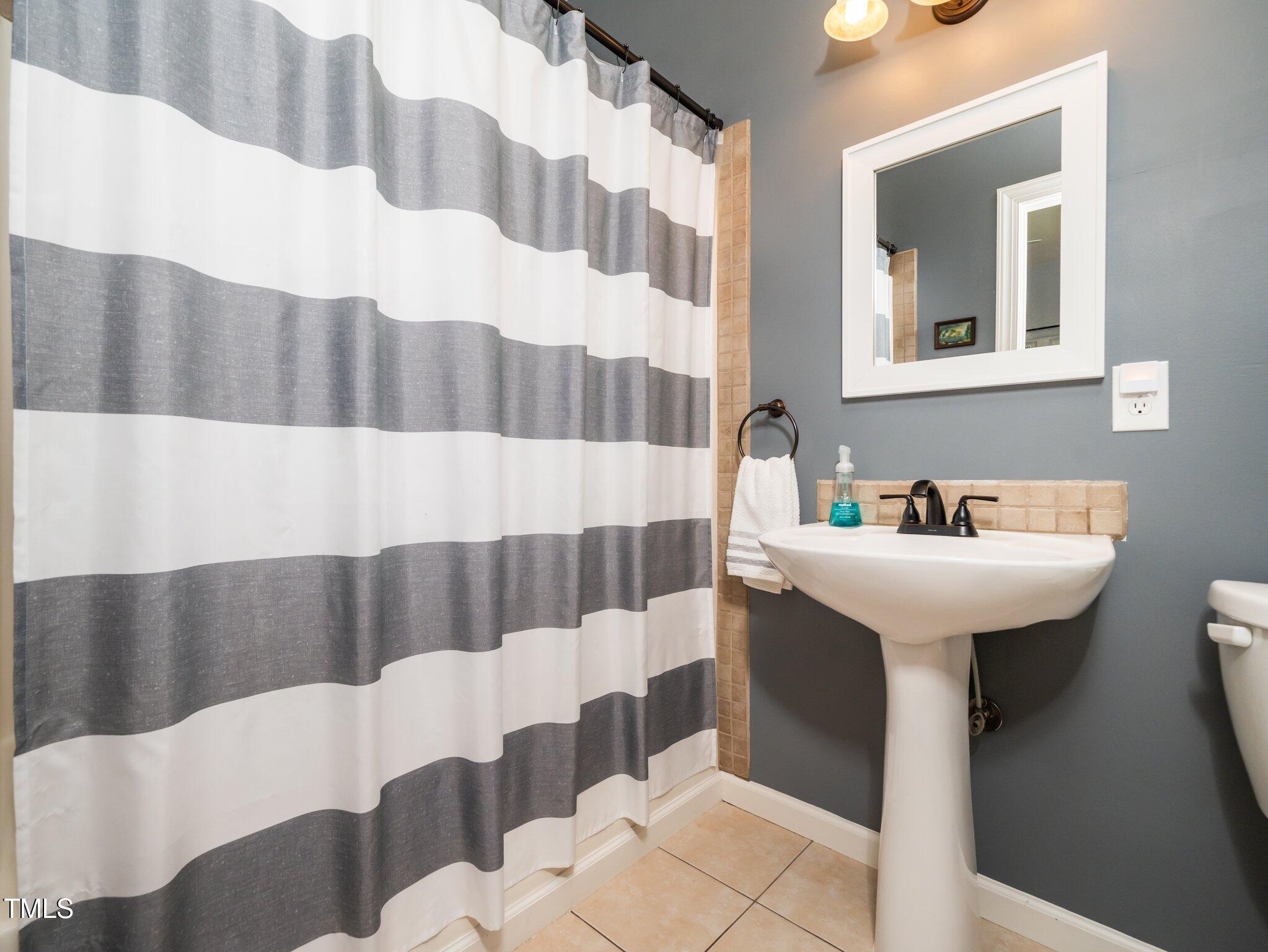 8917 Thompson Mill Road Wake Forest, NC 27587 - Photo 16 of 42 a bathroom with a sink and a mirror
