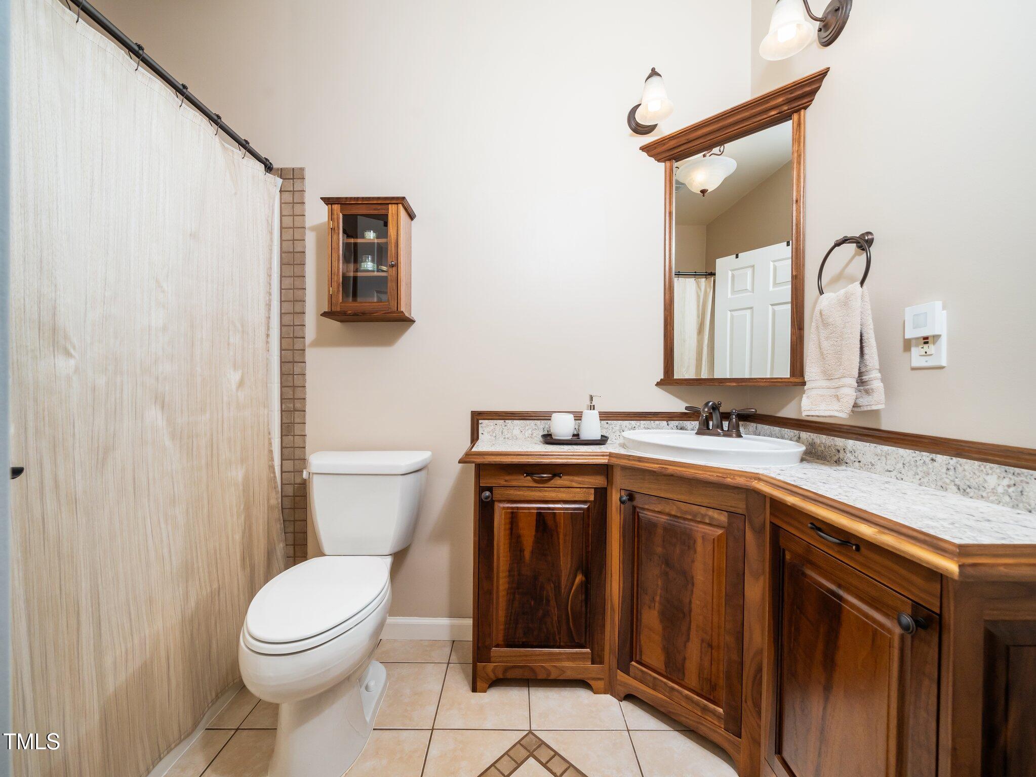 8917 Thompson Mill Road Wake Forest, NC 27587 - Photo 18 of 42 a bathroom with a sink a toilet and a mirror