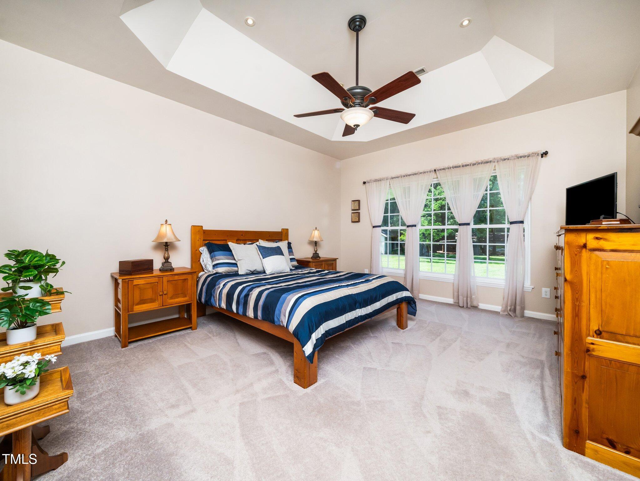 8917 Thompson Mill Road Wake Forest, NC 27587 - Photo 21 of 42 a bedroom with a bed and a chandelier