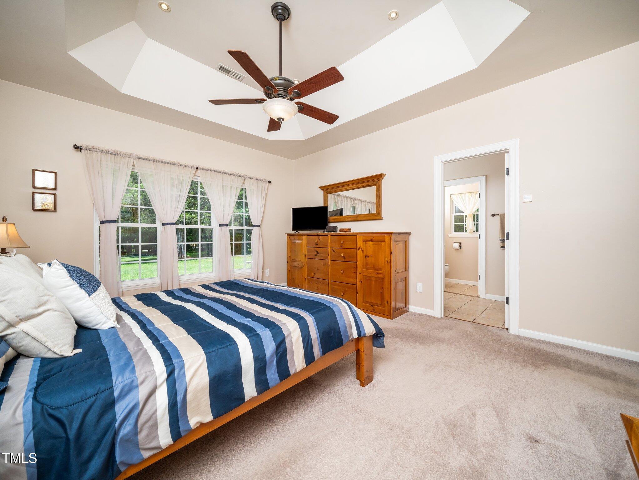 8917 Thompson Mill Road Wake Forest, NC 27587 - Photo 22 of 42 a spacious bedroom with a bed and a chandelier