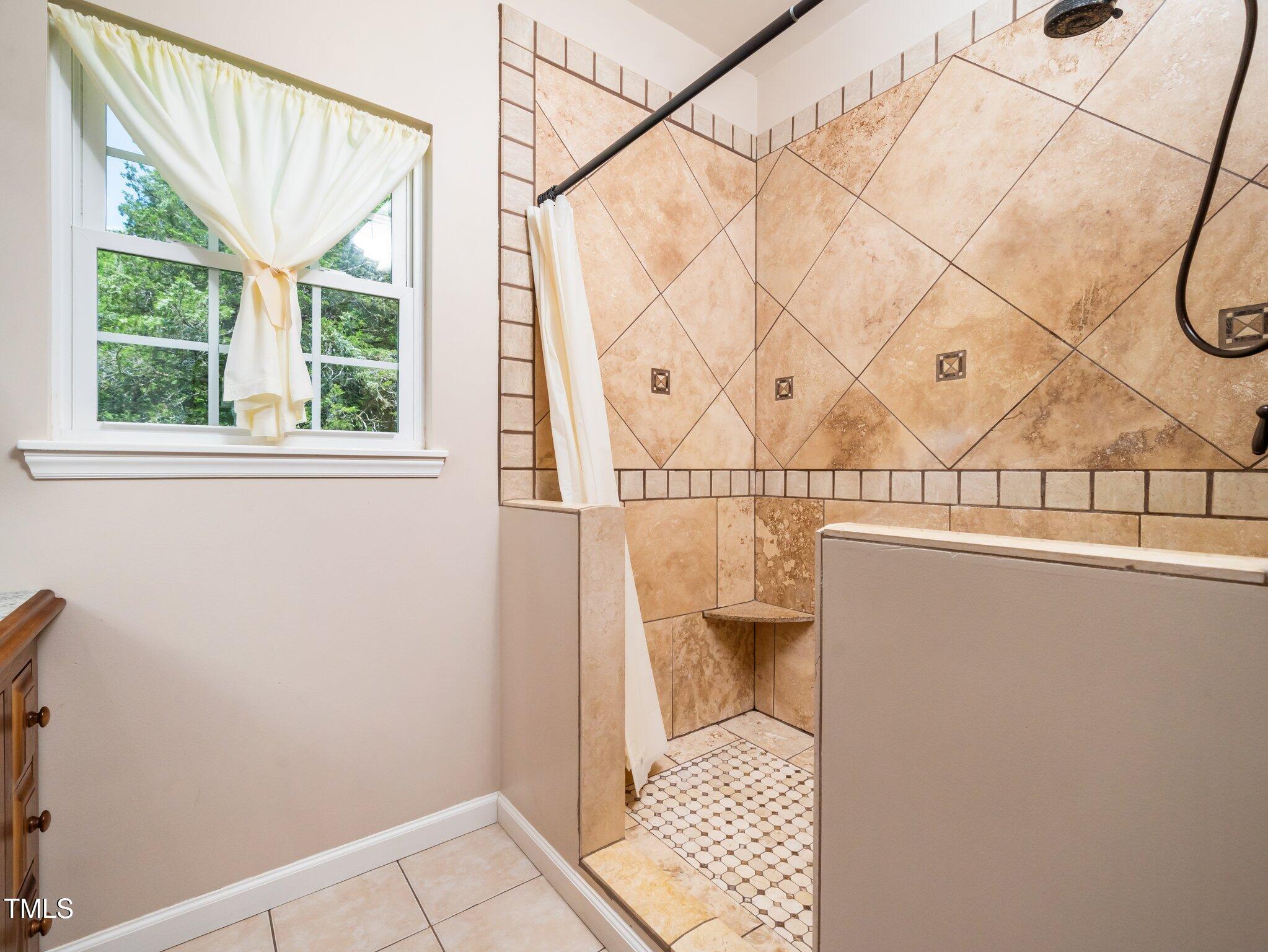 8917 Thompson Mill Road Wake Forest, NC 27587 - Photo 24 of 42 a bathroom with a window a sink and a shower