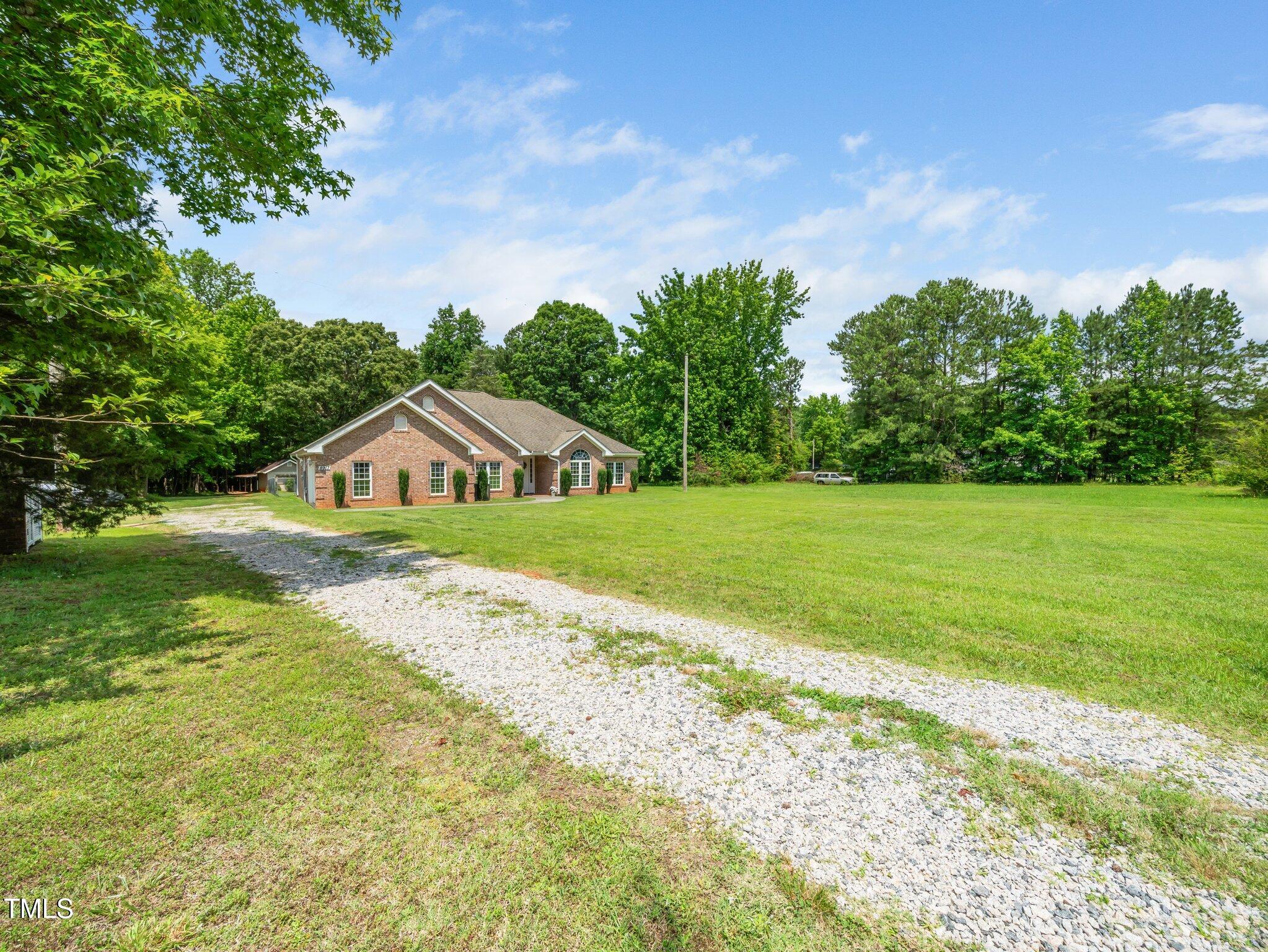 8917 Thompson Mill Road Wake Forest, NC 27587 - Photo 3 of 42 a view of a house with a big yard and large trees