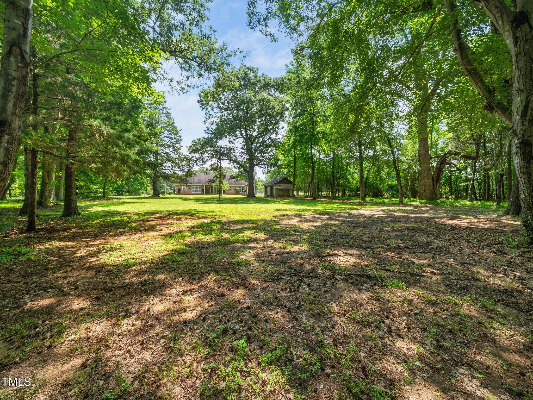 8917 Thompson Mill Road Wake Forest, NC 27587 - Photo 37 of 42 a big yard with lots of green space and trees in the background