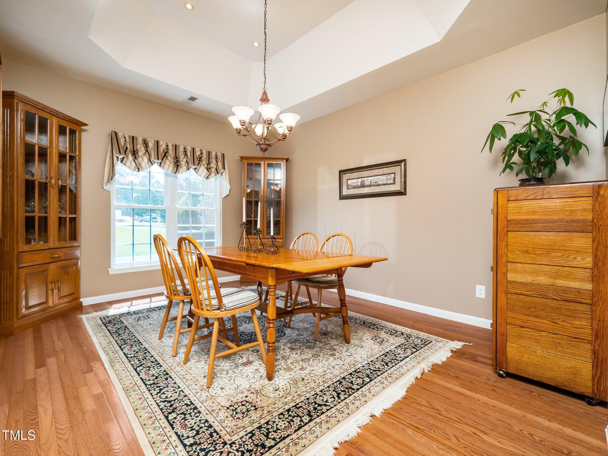 8917 Thompson Mill Road Wake Forest, NC 27587 - Photo 7 of 42 a view of a dining room with furniture window and wooden floor