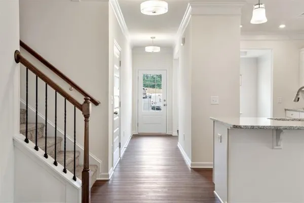 a view of a hallway with wooden floor and staircase