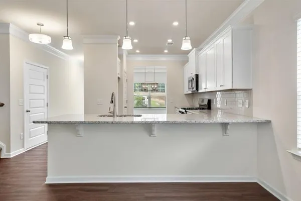 a view of a kitchen with wooden floor and cabinets