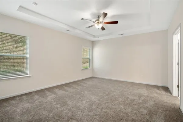 an empty room with windows and fan