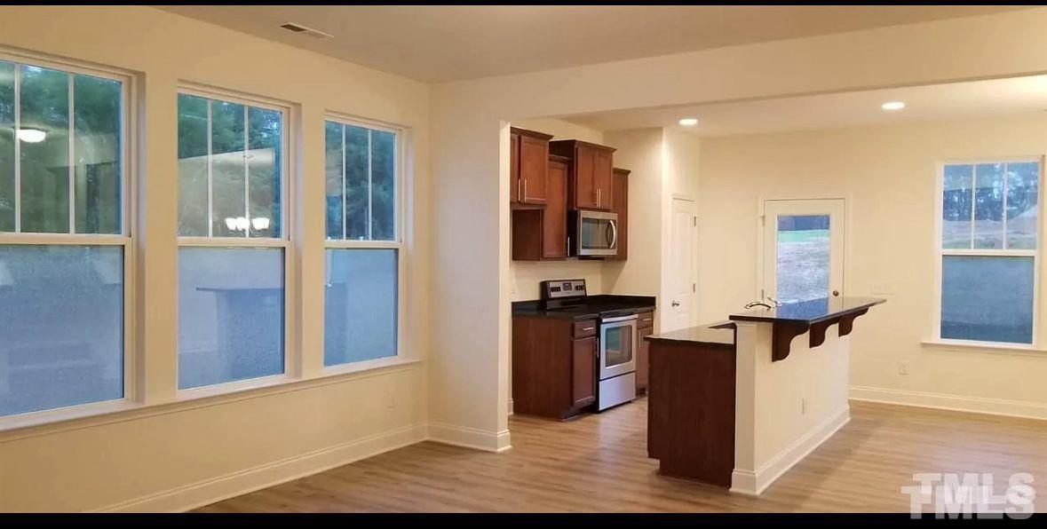 189 Wethergate Drive Clayton, NC 27527 - Photo 3 of 8 a view of living room kitchen with stainless steel appliances wooden floor and large window