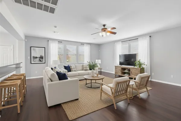 a living room with furniture a flat screen tv and a window