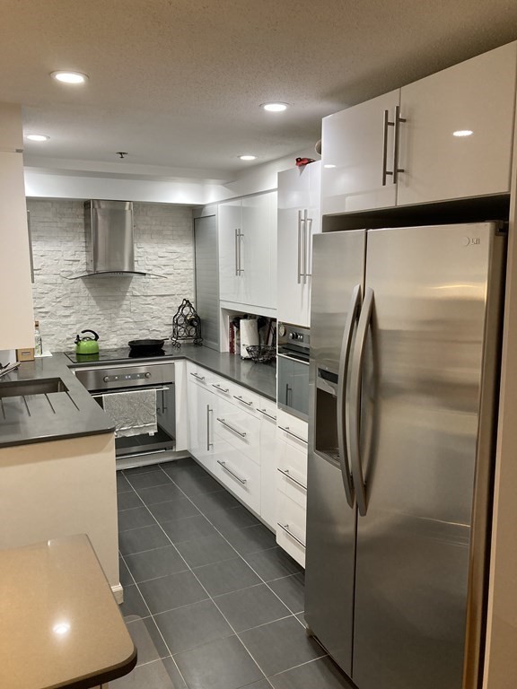 357 Commercial Street, Unit 617 Boston, MA 02109 - Photo 7 of 15 a kitchen with a refrigerator sink and cabinets