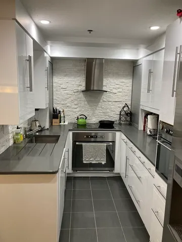 a living room with furniture a flat screen tv and kitchen view