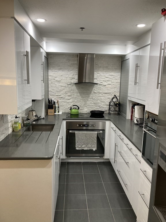 357 Commercial Street, Unit 617 Boston, MA 02109 - Photo 8 of 15 a kitchen with a stove sink and cabinets
