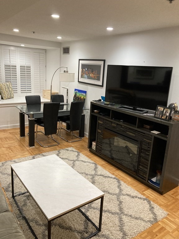 357 Commercial Street, Unit 617 Boston, MA 02109 - Photo 9 of 15 a living room with furniture a flat screen tv and kitchen view