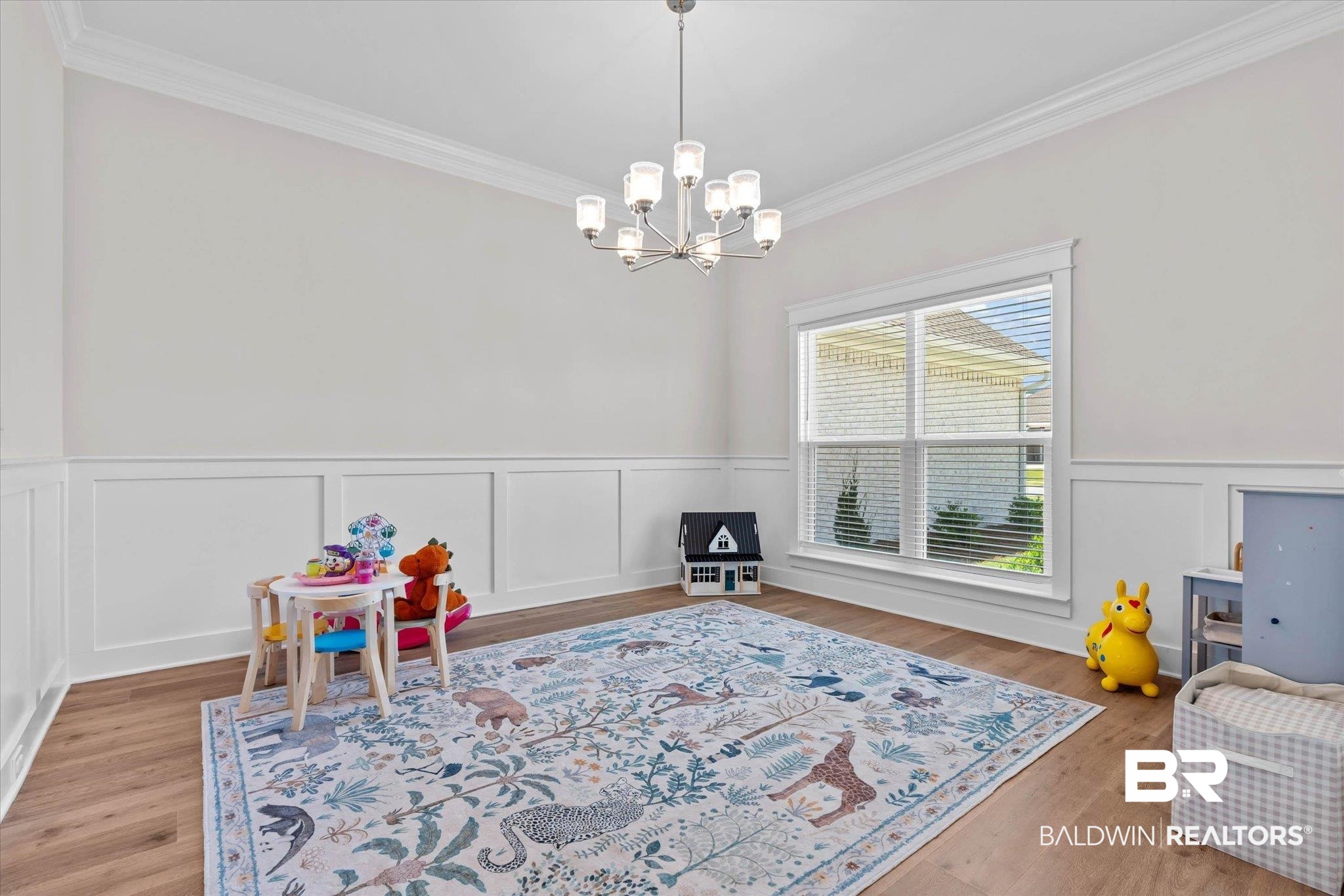 23523 Travis Stock Street Foley, AL 36535 - Photo 4 of 45 Spacious room featuring wood-finish flooring, wainscoting, crown molding, and a multi-pane window with blinds