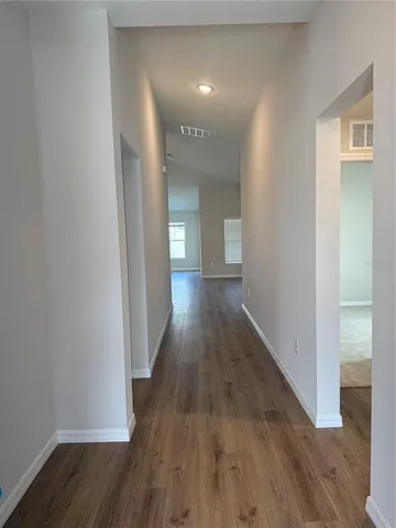a view of a hallway with wooden floor