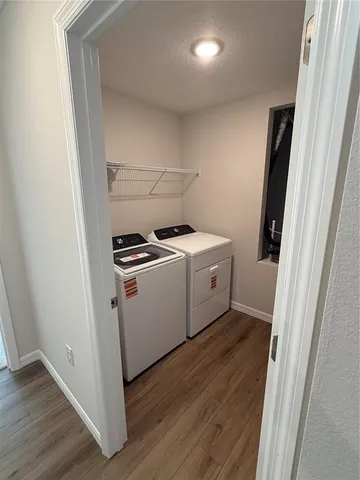 a utility room with wooden floor washer and dryer