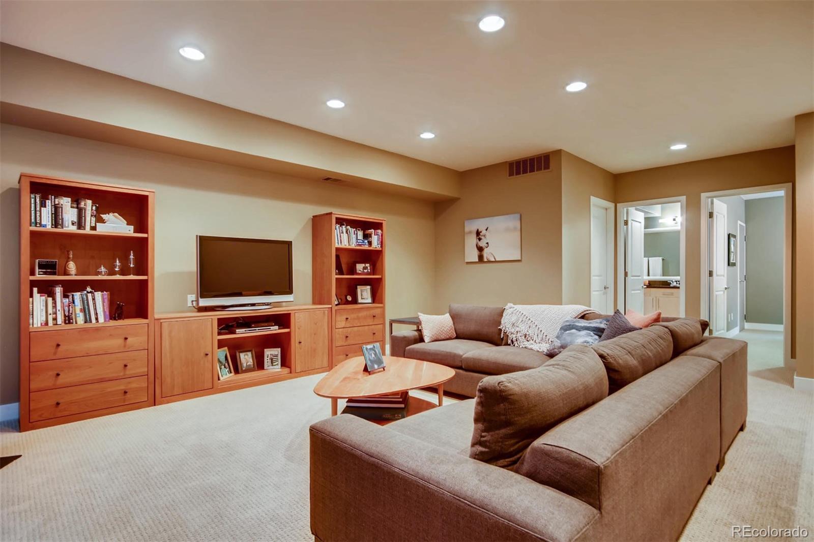 3231 Perry Street Denver, CO 80212 - Photo 24 of 36 a living room with furniture a flat screen tv and a bookshelf