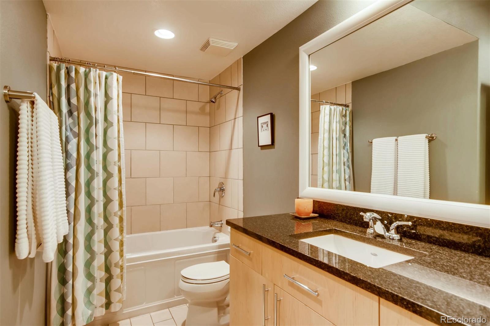 3231 Perry Street Denver, CO 80212 - Photo 27 of 36 a bathroom with a granite countertop sink toilet mirror and shower