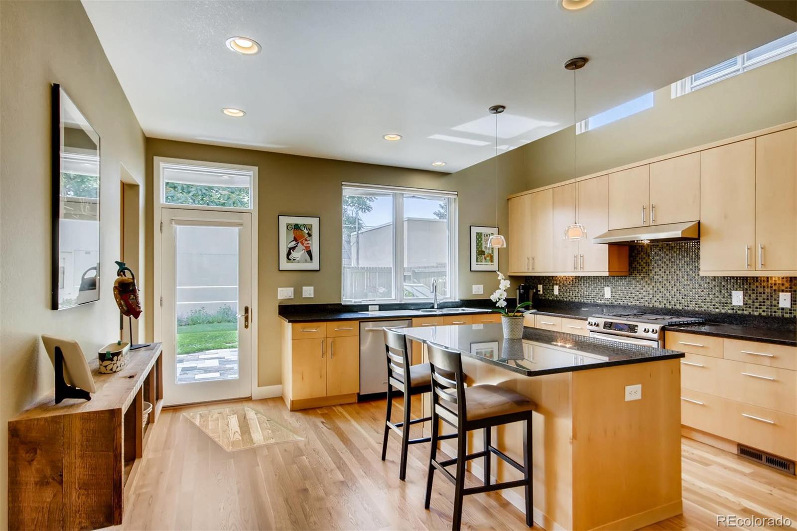 3231 Perry Street Denver, CO 80212 - Photo 7 of 36 a kitchen with stainless steel appliances granite countertop a stove top oven a sink dishwasher a dining table and chairs with wooden floor