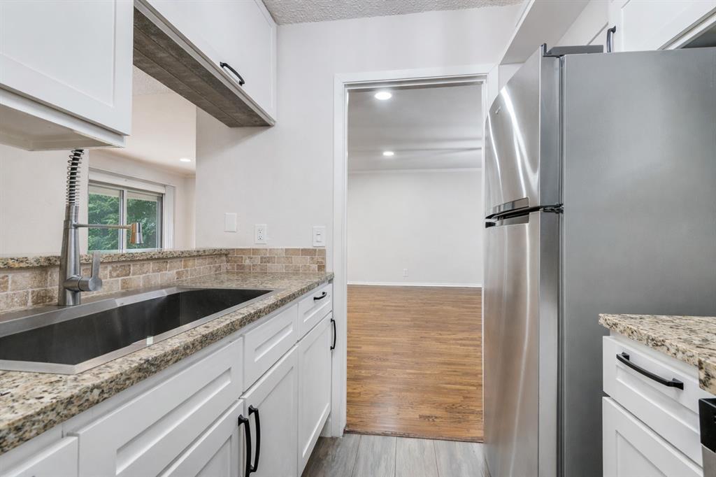 4851 Cedar Springs Road, Unit 383 Dallas, TX 75219 - Photo 2 of 19 a view of a kitchen from a hallway