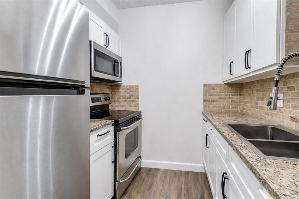 4851 Cedar Springs Road, Unit 383 Dallas, TX 75219 - Photo 3 of 19 a kitchen with stainless steel appliances granite countertop a refrigerator and a sink