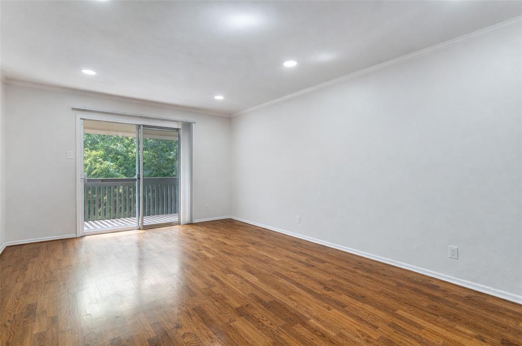 4851 Cedar Springs Road, Unit 383 Dallas, TX 75219 - Photo 7 of 19 a view of an empty room with wooden floor and a window