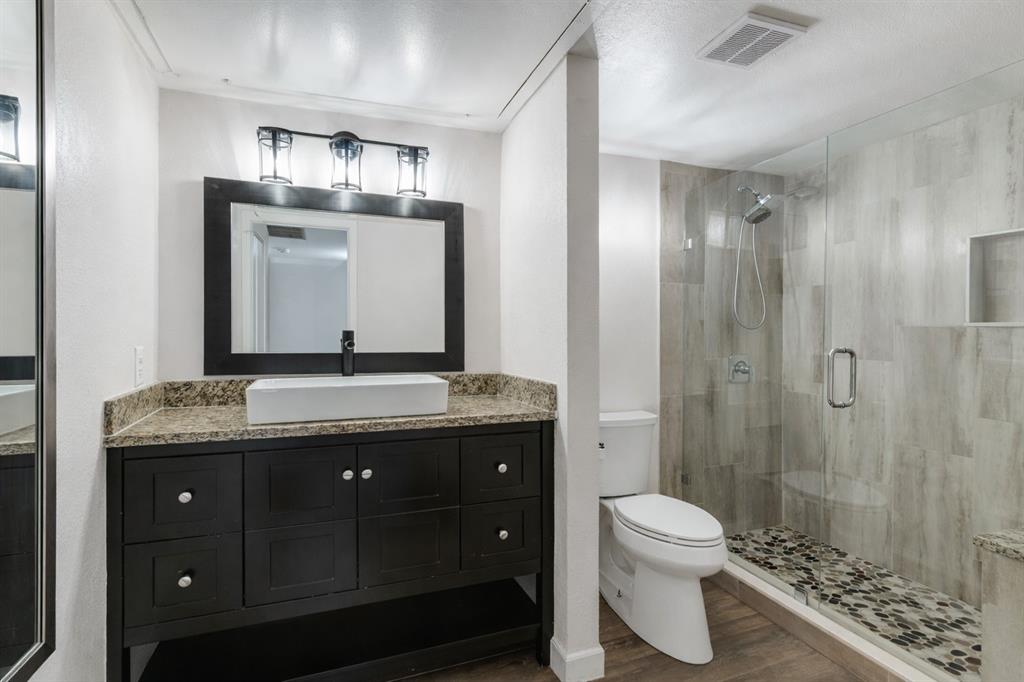 4851 Cedar Springs Road, Unit 383 Dallas, TX 75219 - Photo 9 of 19 a bathroom with a granite countertop sink toilet and shower