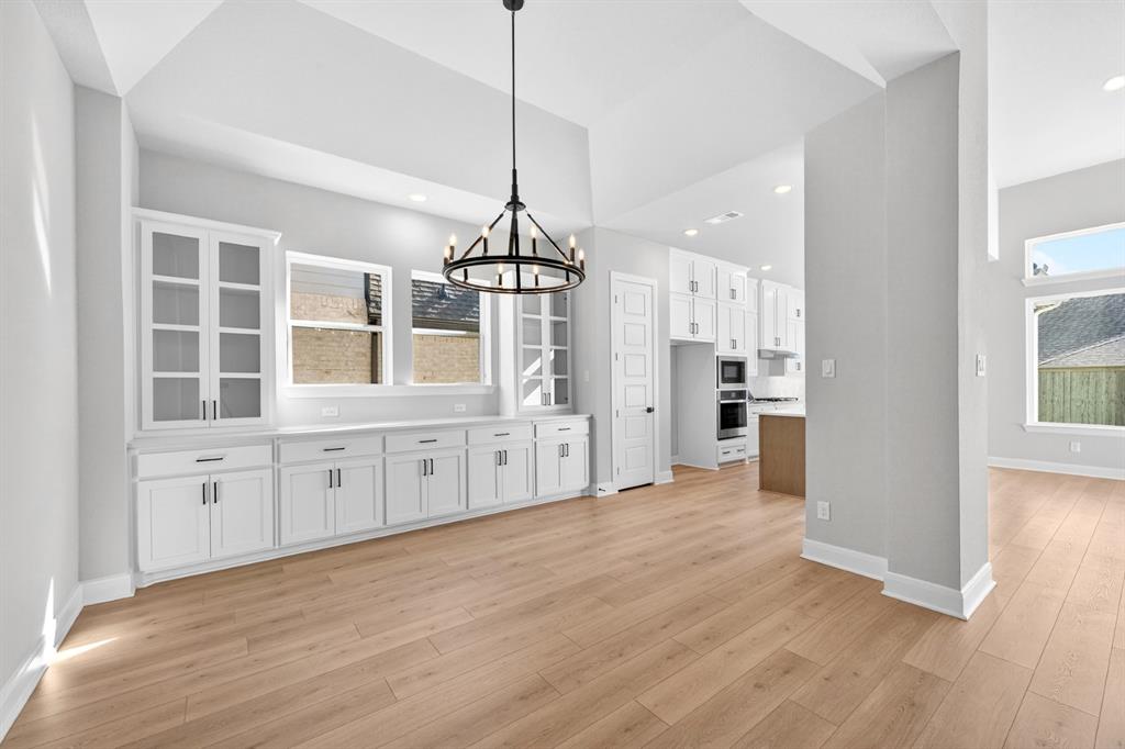 2109 Chance Lane Northlake, TX 76247 - Photo 9 of 36 a large kitchen with cabinets wooden floor and a chandelier