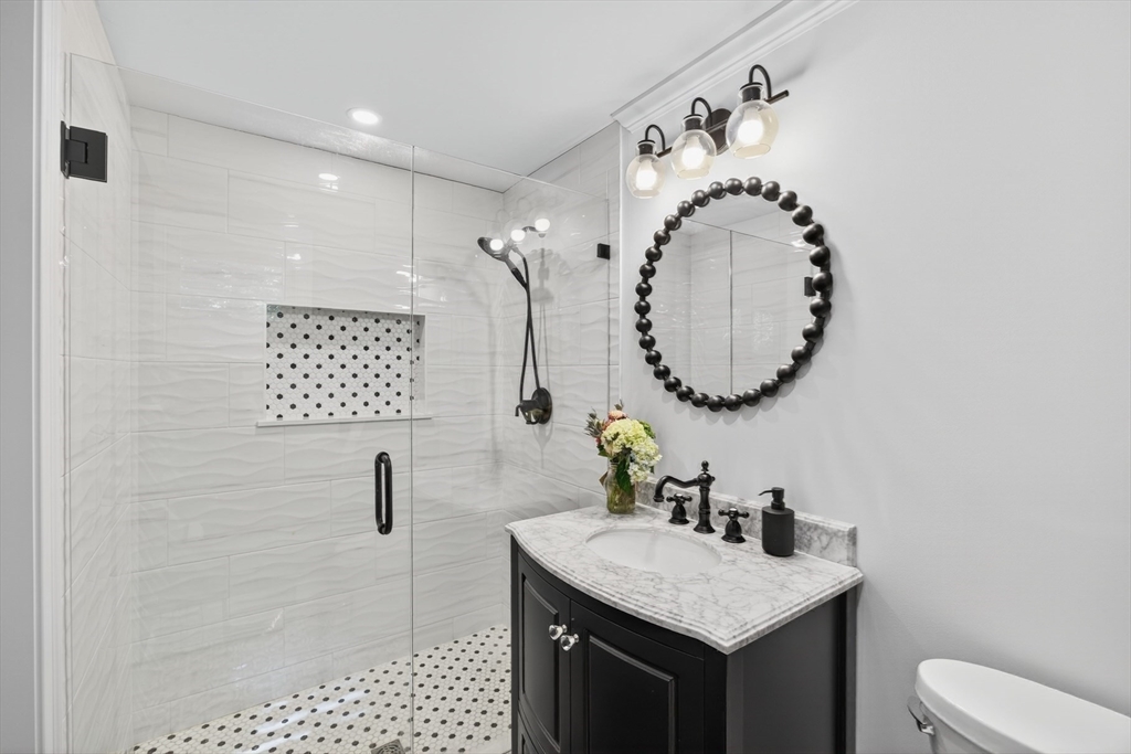 128 Uncle Percy's Road Mashpee, MA 02649 - Photo 15 of 42 a bathroom with a granite countertop sink a mirror and a toilet