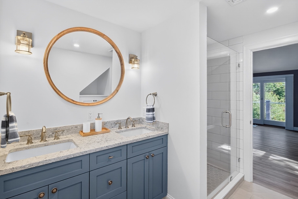 128 Uncle Percy's Road Mashpee, MA 02649 - Photo 24 of 42 a bathroom with a granite countertop double vanity sinks and a mirror
