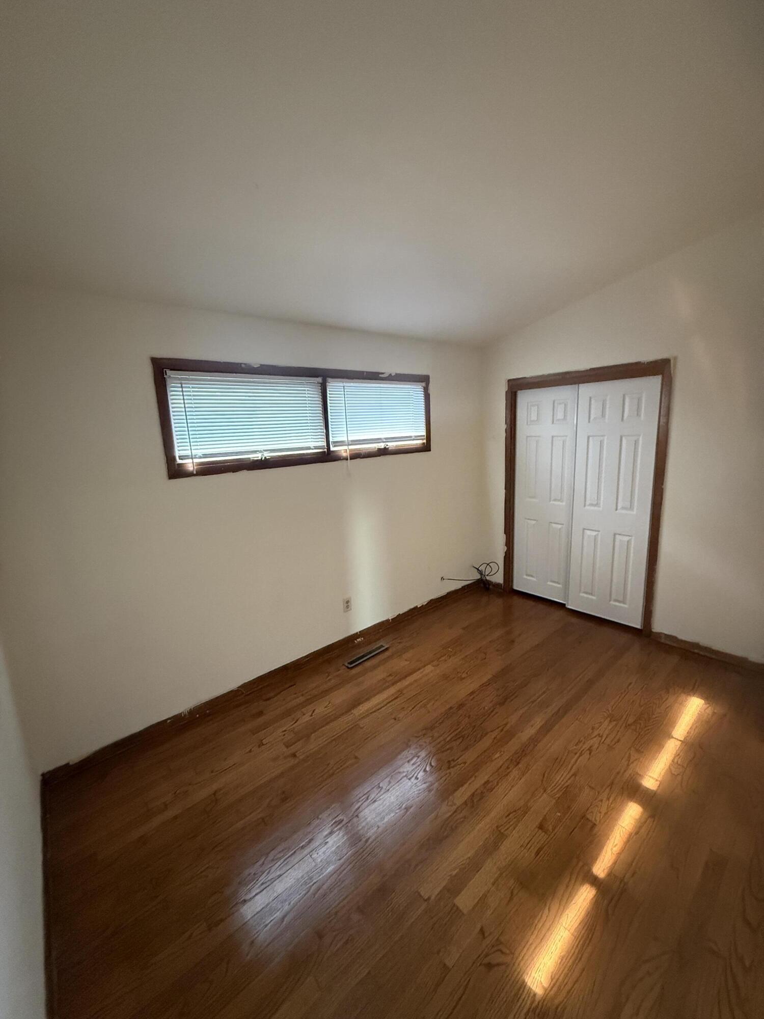 7809 Indian Boundary Gary, IN 46403 - Photo 4 of 13 a view of an empty room with wooden floor and window