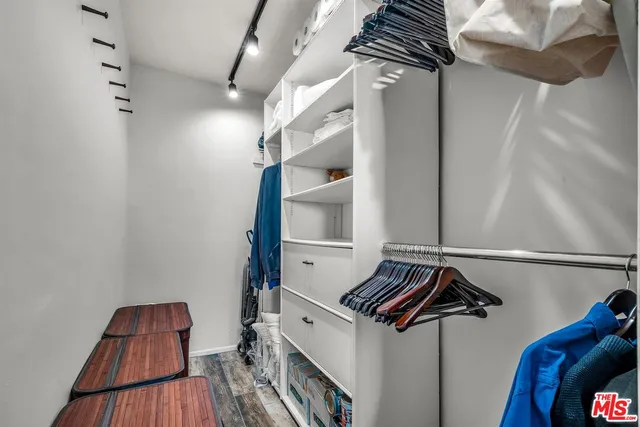 a view of walk in closet with clothes and shoes