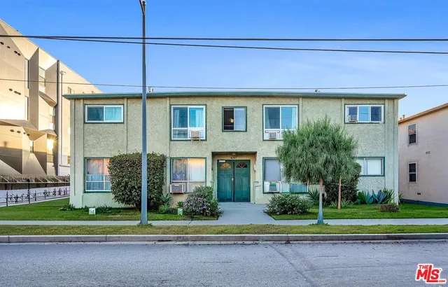 a front view of a house with a yard and plants