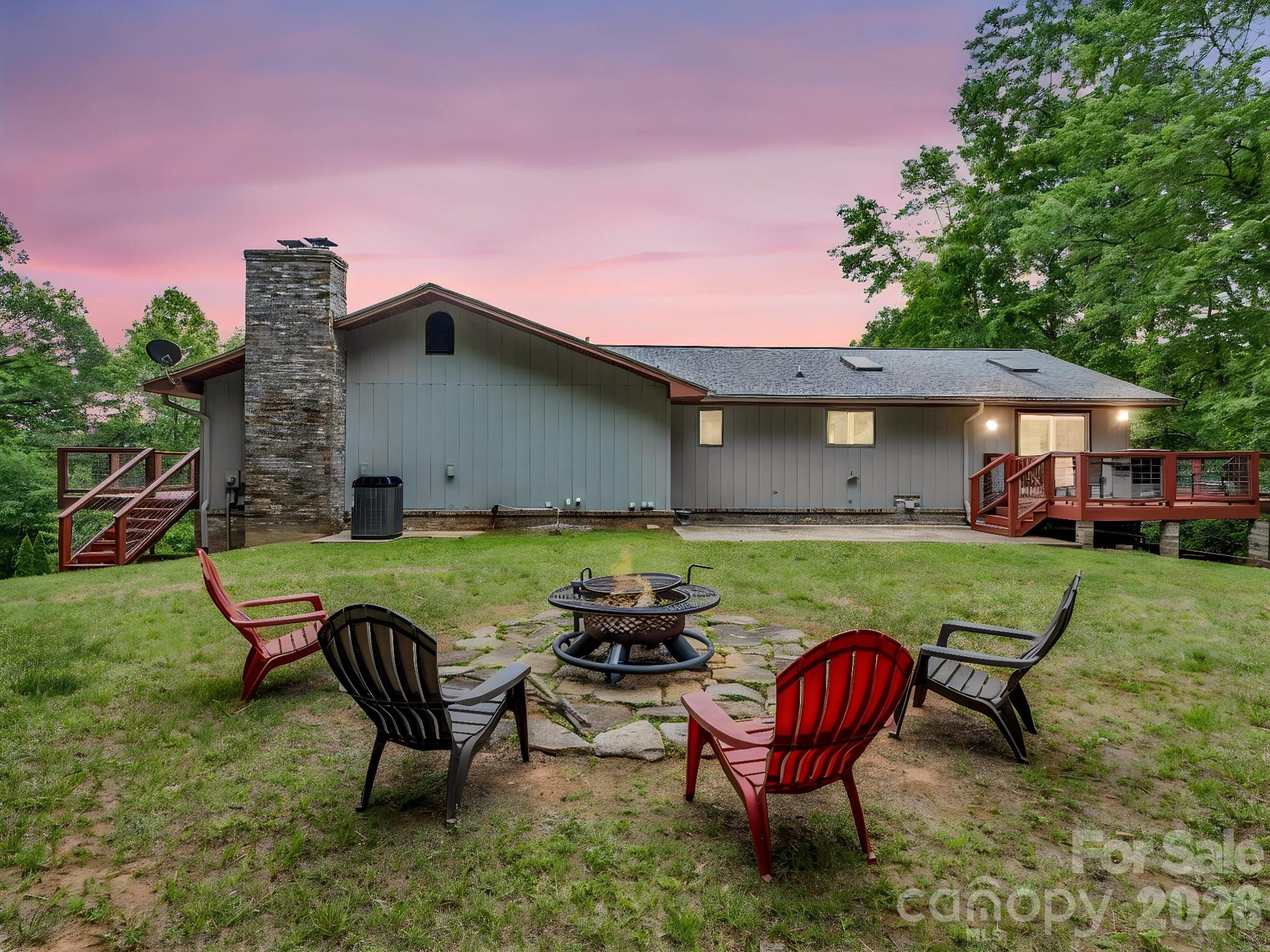 656 Cashiers Valley Road Brevard, NC 28712 - Photo 2 of 37 a view of a house with a yard and chairs