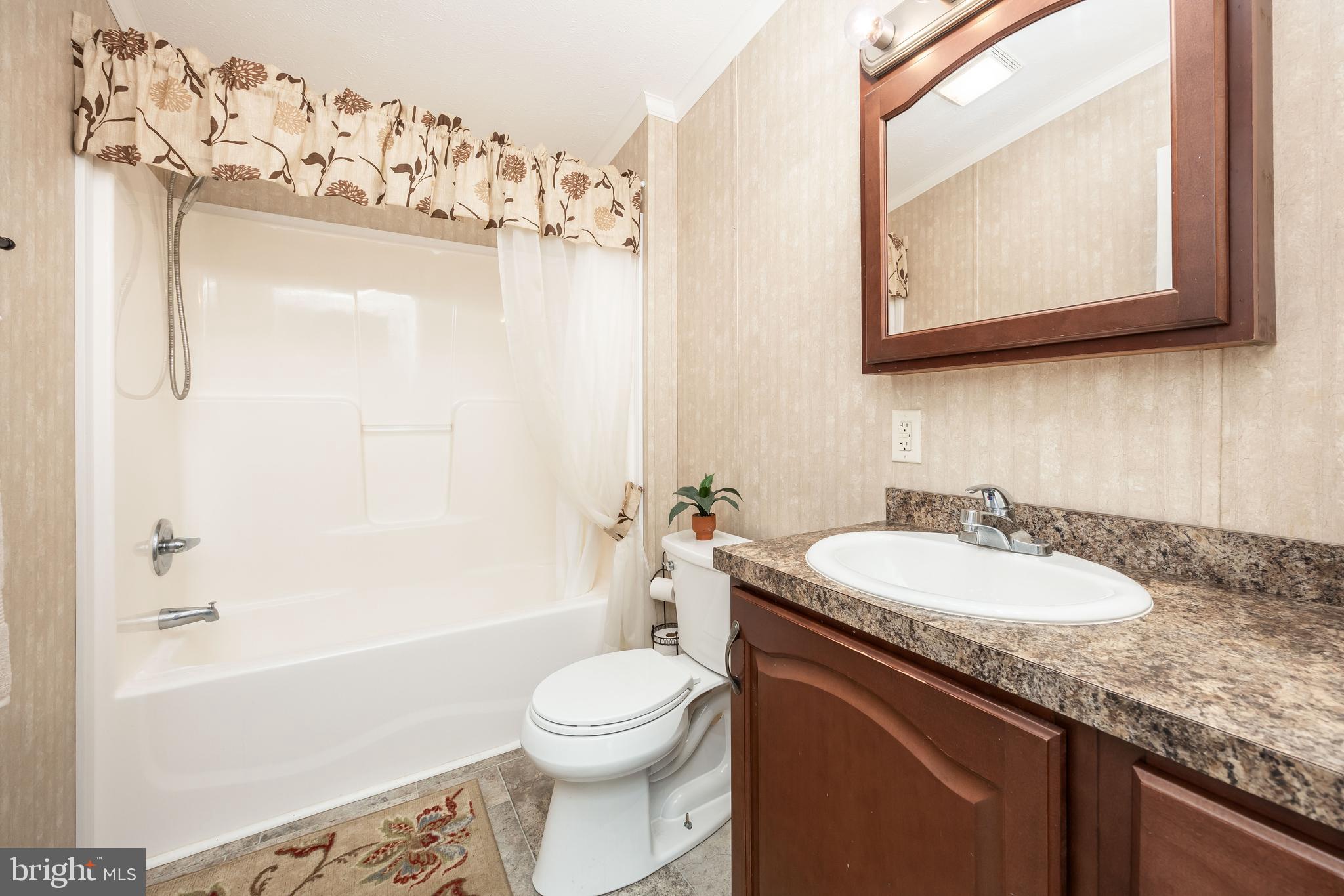 4258 Smith Road Salisbury, MD 21801 - Photo 37 of 43 a bathroom with a granite countertop sink mirror toilet and bathtub
